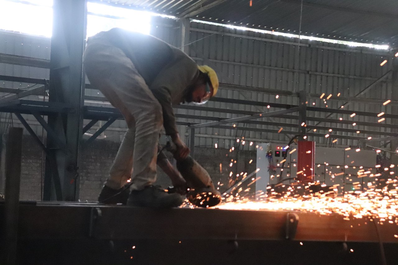 GoldLine Factory worker grinding with angle grinder